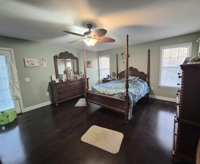 bedroom featuring ceiling fan, dark wood-type flooring, and multiple windows