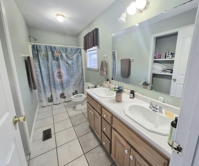 bathroom featuring toilet, vanity, tile patterned flooring, and curtained shower