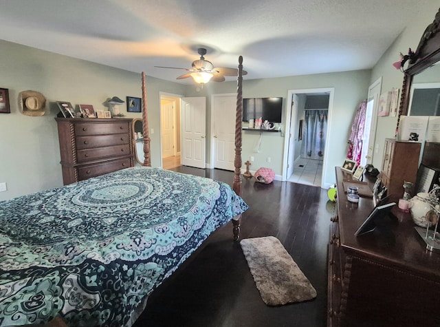 bedroom featuring ceiling fan, dark hardwood / wood-style flooring, and connected bathroom