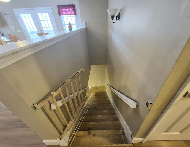 stairs featuring french doors and hardwood / wood-style flooring