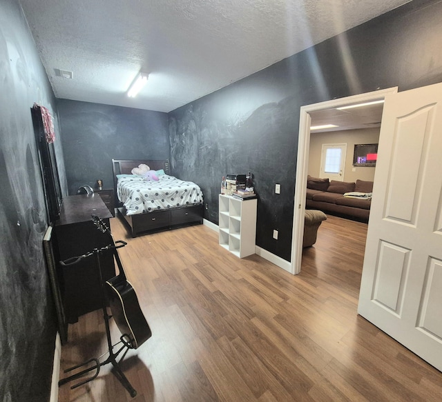 bedroom featuring a textured ceiling and hardwood / wood-style floors