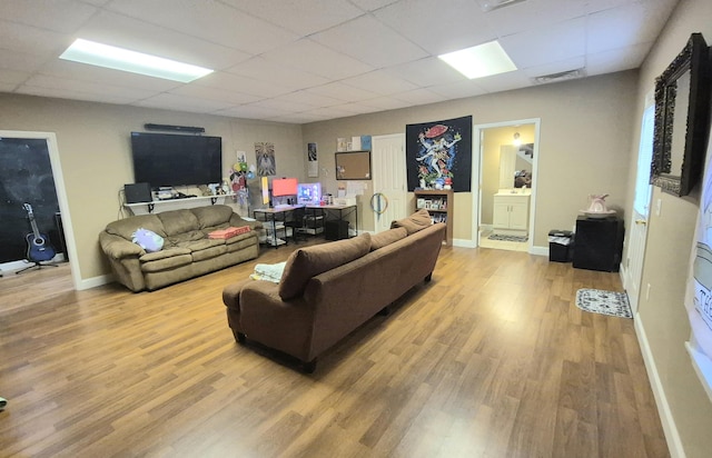 living room featuring light hardwood / wood-style floors and a paneled ceiling