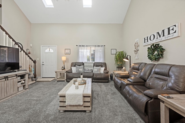 living room with a skylight, high vaulted ceiling, and dark carpet