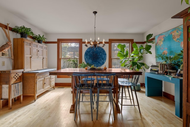 dining room with light hardwood / wood-style floors and an inviting chandelier