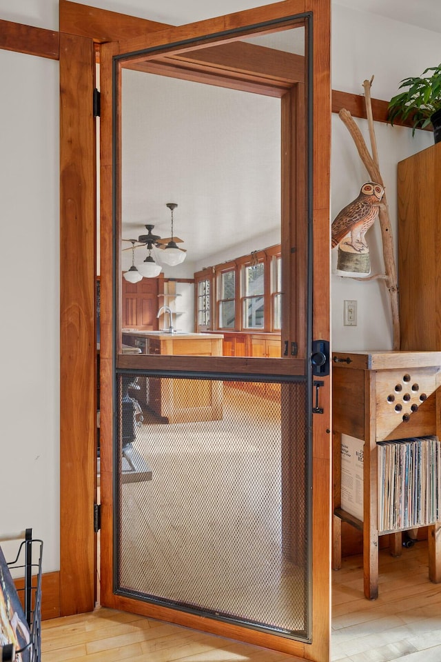 doorway with light hardwood / wood-style floors and sink