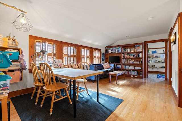 dining area with vaulted ceiling and light hardwood / wood-style flooring