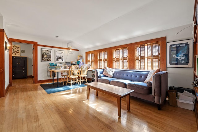 living room with light hardwood / wood-style floors and lofted ceiling