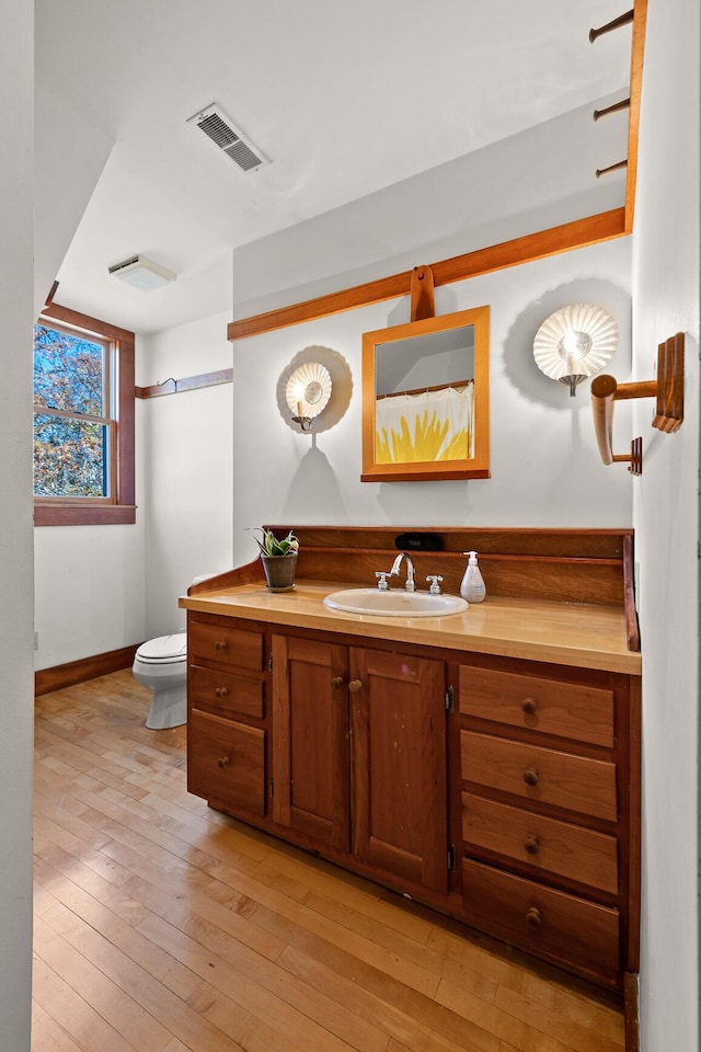 bathroom featuring hardwood / wood-style floors, vanity, and toilet