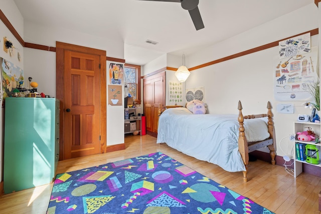 bedroom featuring hardwood / wood-style flooring, ceiling fan, and a closet