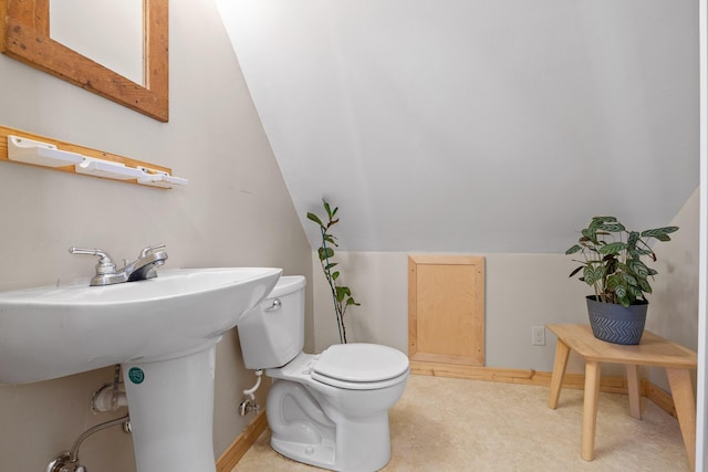 bathroom with lofted ceiling and toilet