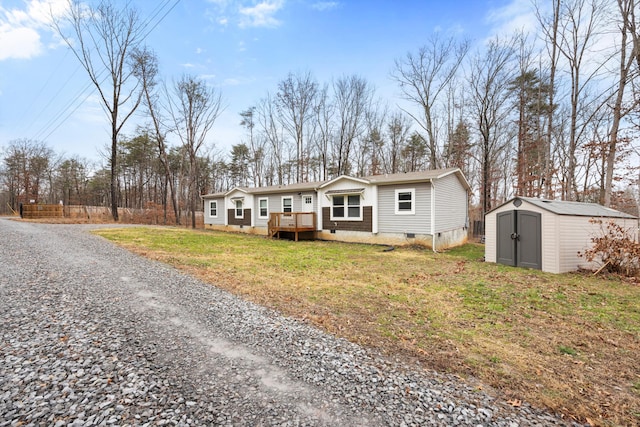 view of front facade featuring a storage unit, a deck, and a front yard