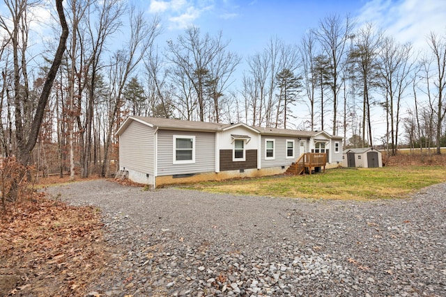 manufactured / mobile home featuring a front lawn and a storage unit