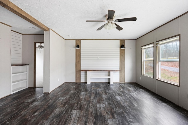 unfurnished living room with ceiling fan, wooden walls, dark wood-type flooring, and a textured ceiling