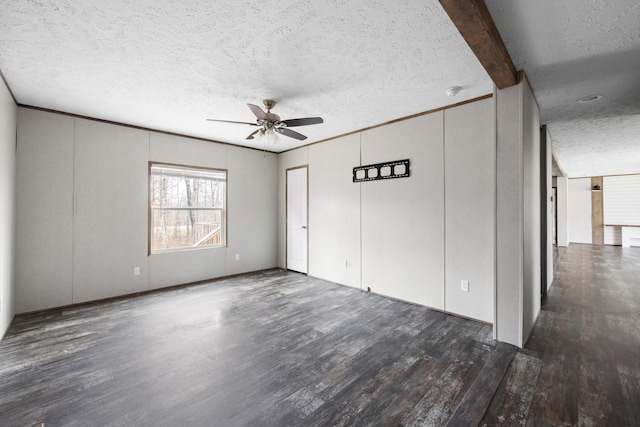 spare room featuring dark hardwood / wood-style floors, ceiling fan, beam ceiling, and a textured ceiling