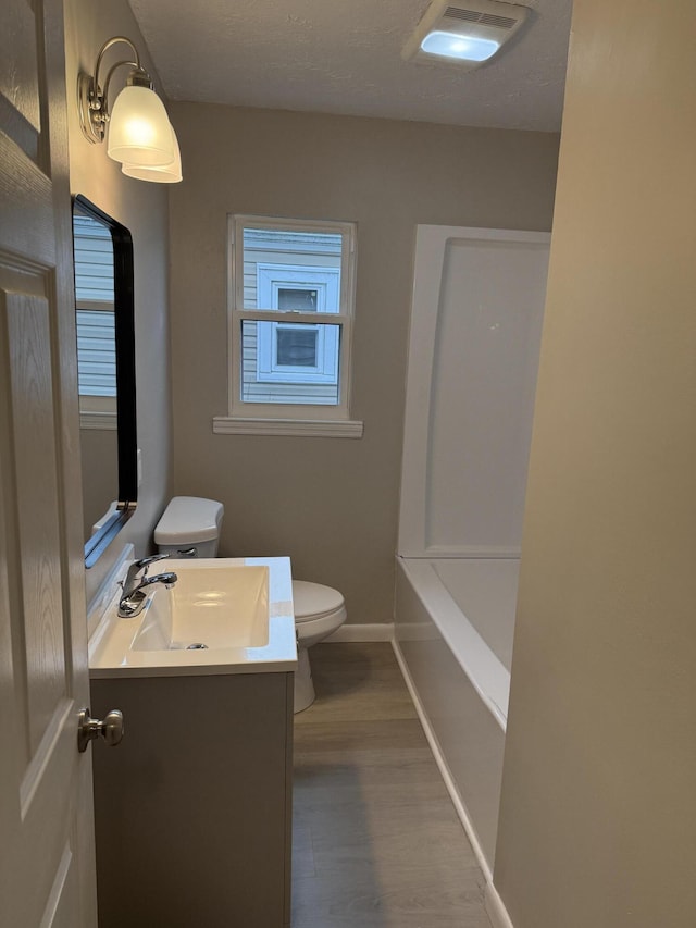 bathroom with vanity, toilet, and wood-type flooring