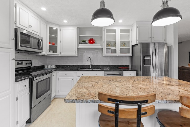 kitchen with pendant lighting, a breakfast bar, and appliances with stainless steel finishes