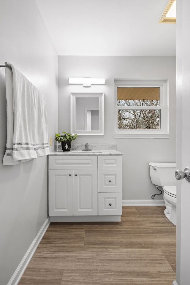 bathroom with hardwood / wood-style floors, vanity, and toilet