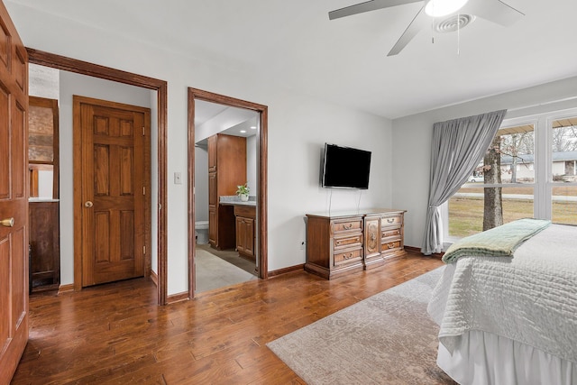 bedroom with connected bathroom, ceiling fan, and wood-type flooring