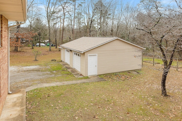 view of outbuilding featuring a garage and a lawn