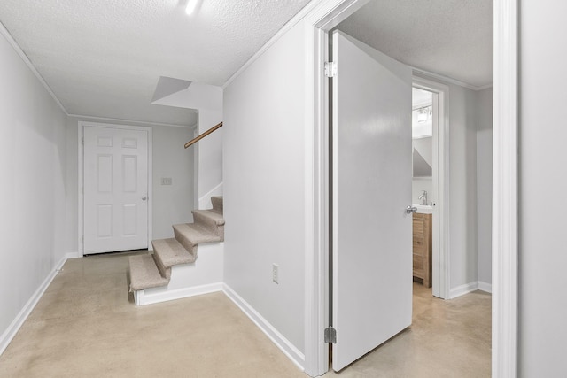 stairs with a textured ceiling and concrete floors