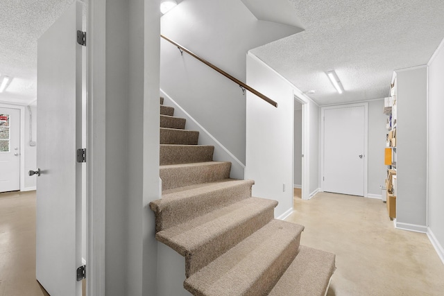 stairway featuring a textured ceiling