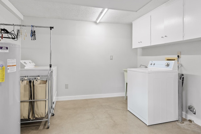 laundry room with water heater, washer and clothes dryer, cabinets, and a textured ceiling