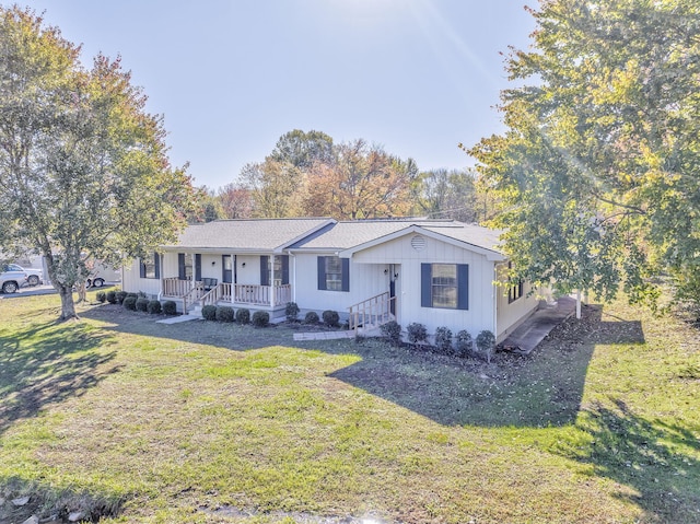 ranch-style home featuring covered porch and a front lawn