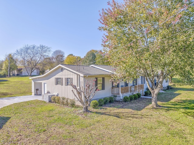 view of side of property featuring a lawn, a porch, and a garage