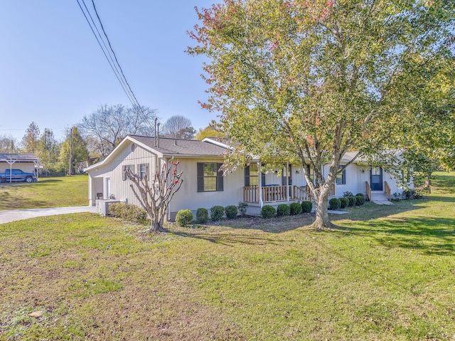 view of front of property featuring a front lawn, covered porch, and a garage