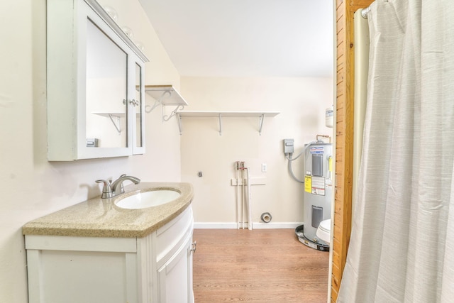 washroom with hookup for a washing machine, sink, light hardwood / wood-style flooring, and water heater