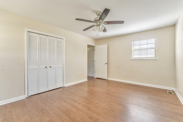 unfurnished bedroom featuring ceiling fan, light hardwood / wood-style floors, and a closet