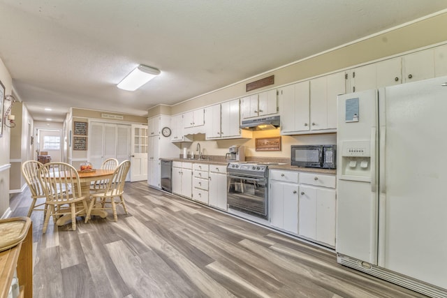 kitchen featuring white cabinetry, sink, stainless steel appliances, light hardwood / wood-style flooring, and a textured ceiling