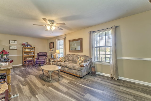 living room with a textured ceiling, ceiling fan, and dark wood-type flooring