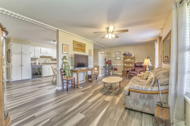 living room with ceiling fan, light wood-type flooring, and sink