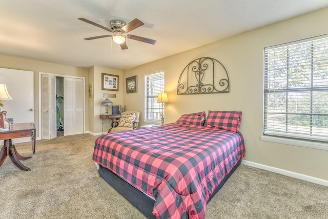 carpeted bedroom featuring ceiling fan and multiple windows