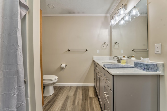 bathroom with crown molding, a textured ceiling, toilet, vanity, and hardwood / wood-style flooring