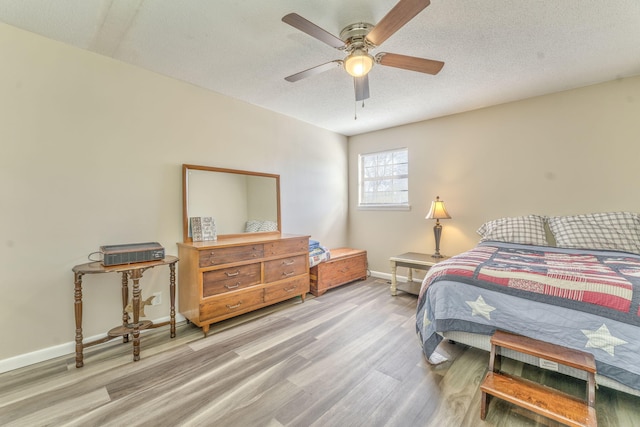 bedroom featuring hardwood / wood-style flooring, ceiling fan, and a textured ceiling