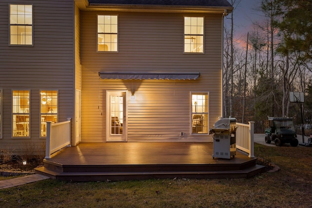 back house at dusk featuring a wooden deck