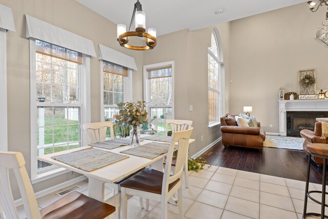 dining space featuring an inviting chandelier, tile patterned floors, and plenty of natural light