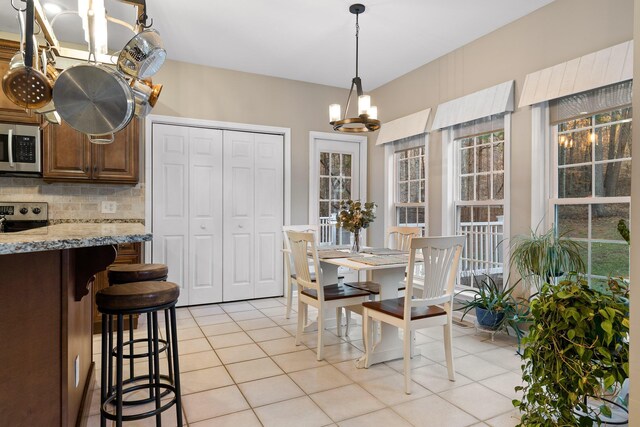 tiled dining room featuring a chandelier