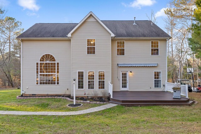 rear view of house featuring a lawn and a deck