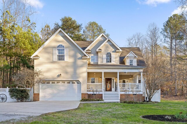 view of front of house with a garage, a front yard, and covered porch