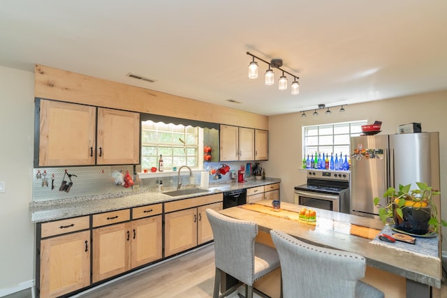 kitchen featuring light brown cabinetry, light wood-type flooring, stainless steel appliances, and sink