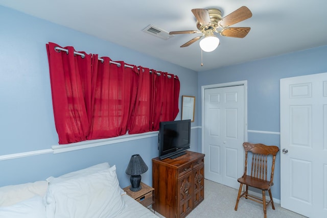 bedroom featuring a closet, light colored carpet, and ceiling fan