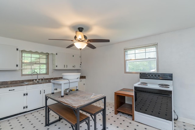 kitchen featuring white cabinetry, sink, plenty of natural light, and white electric range