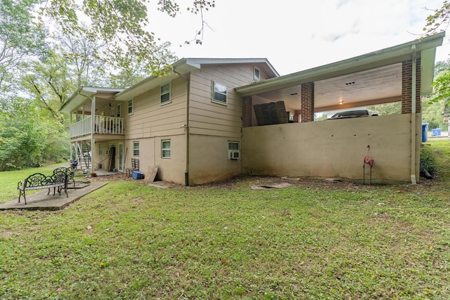 rear view of house featuring a patio area, a yard, and a balcony