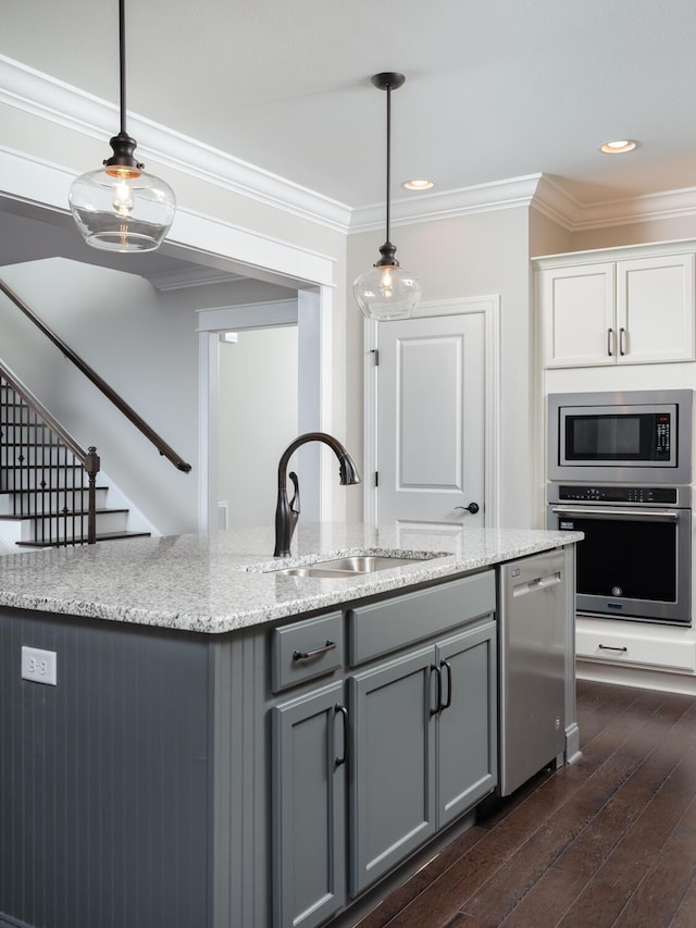 kitchen featuring dark hardwood / wood-style flooring, hanging light fixtures, stainless steel appliances, and sink