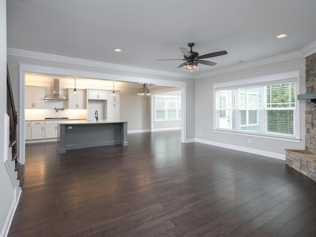 unfurnished living room with crown molding, a healthy amount of sunlight, dark hardwood / wood-style flooring, and sink