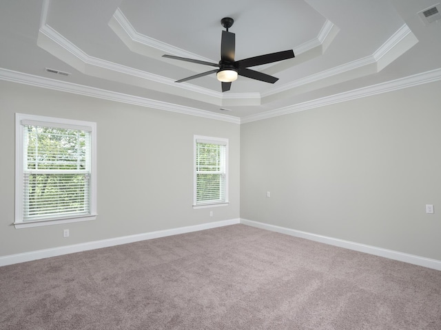 empty room featuring carpet flooring, ceiling fan, a raised ceiling, and ornamental molding