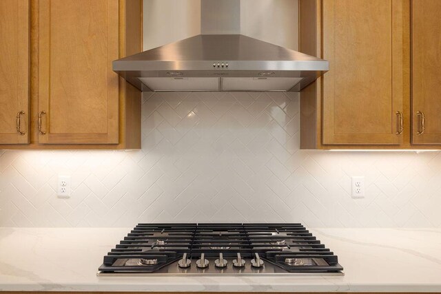 9089 Knolling Loop Unit 87, Ooltewah, TN 37363 - kitchen with wall chimney range hood, stainless steel gas cooktop, light stone counters, and decorative backsplash